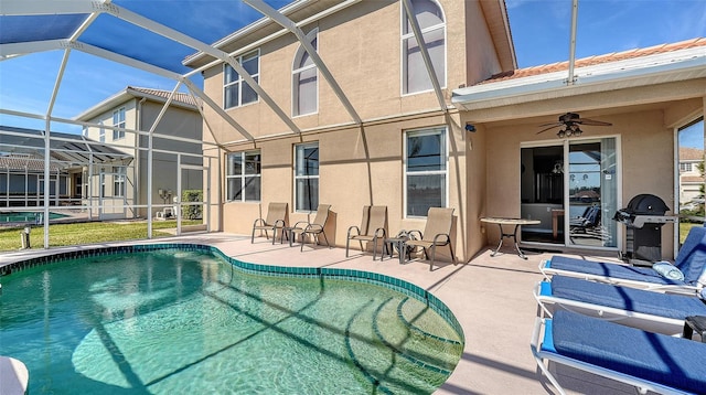 outdoor pool with a lanai, grilling area, a ceiling fan, and a patio