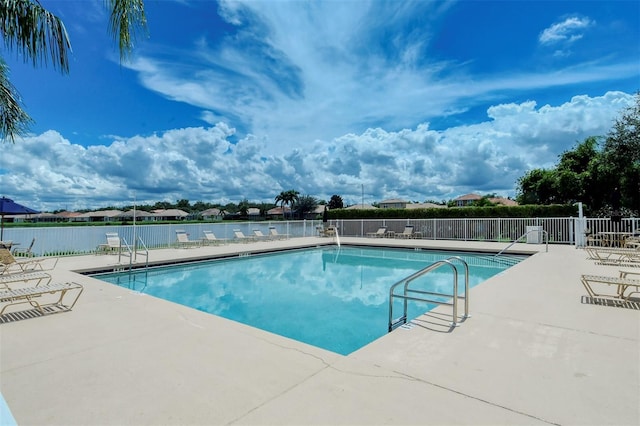 view of swimming pool with a patio area and a water view