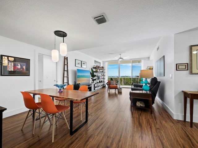 dining area with ceiling fan, dark hardwood / wood-style floors, a textured ceiling, and a wall of windows