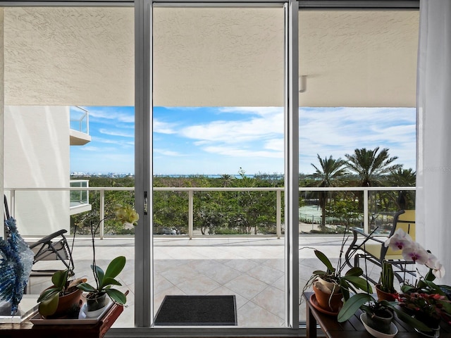 doorway to outside featuring a wall of windows, tile patterned floors, and a water view