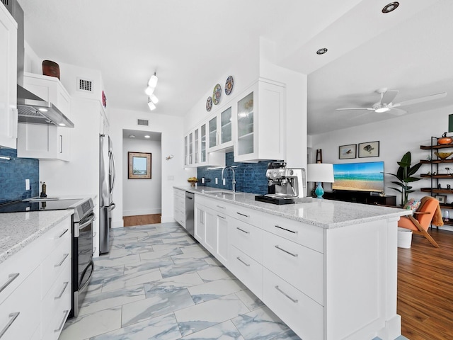 kitchen with stainless steel appliances, light stone countertops, and white cabinets