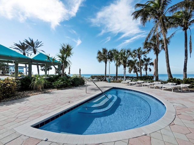 view of swimming pool with a patio area and a water view