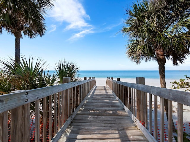 view of home's community with a water view and a beach view