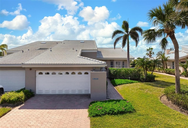 view of front of house featuring a garage and a front lawn