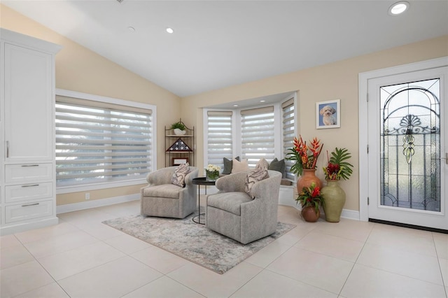 sitting room with light tile patterned floors and vaulted ceiling