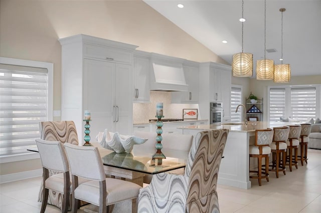 tiled dining room with sink and high vaulted ceiling