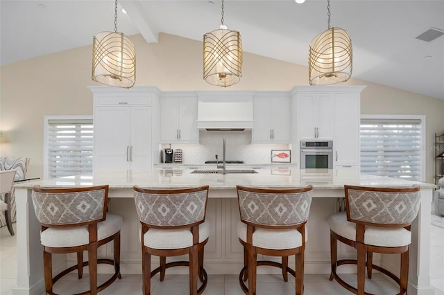 kitchen featuring decorative light fixtures, oven, a kitchen breakfast bar, custom exhaust hood, and a spacious island