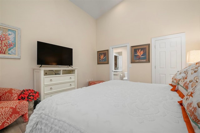 bedroom featuring connected bathroom, vaulted ceiling, and wood-type flooring