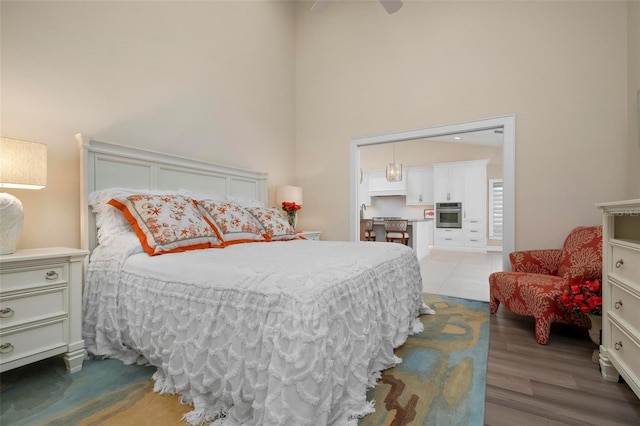 bedroom with hardwood / wood-style floors and a high ceiling