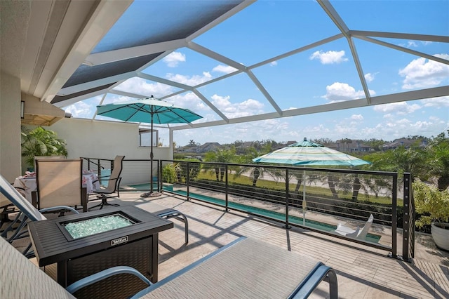 view of patio / terrace featuring a lanai, a pool with hot tub, and a fire pit