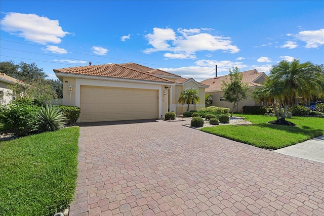 mediterranean / spanish house with a garage and a front yard