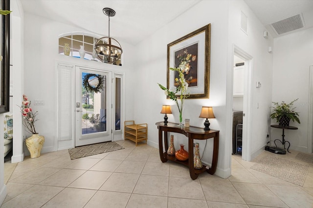 tiled foyer entrance featuring an inviting chandelier