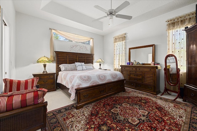 bedroom featuring ceiling fan and a tray ceiling