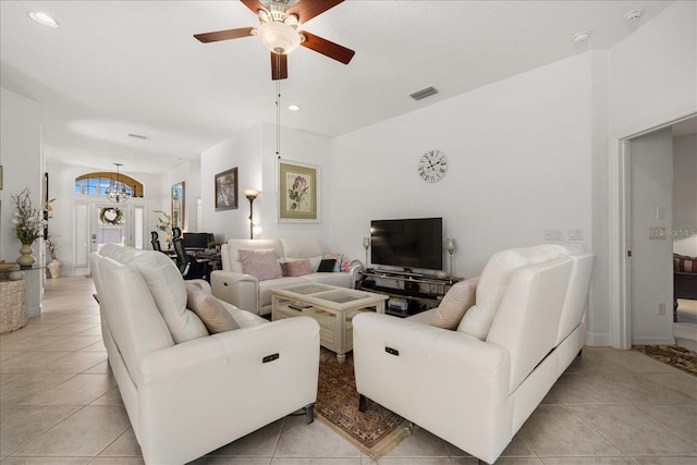 living room featuring ceiling fan with notable chandelier and light tile patterned floors