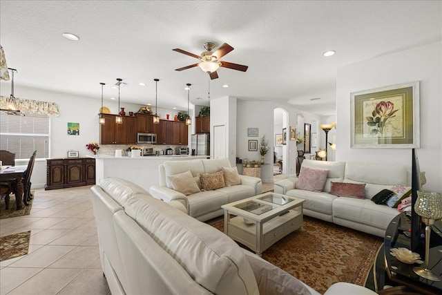 tiled living room featuring ceiling fan and a textured ceiling