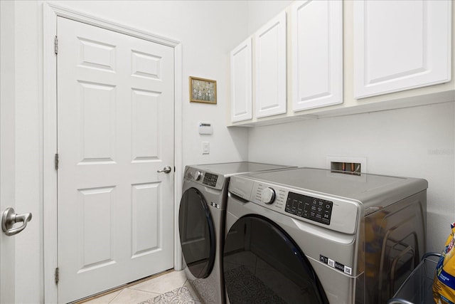 washroom featuring cabinets, light tile patterned floors, and washer and dryer