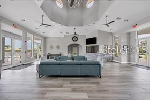 living room with a wealth of natural light, ceiling fan, and light wood-type flooring