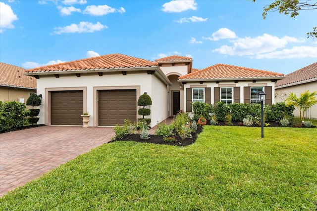 mediterranean / spanish-style house featuring a garage and a front yard