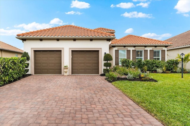 mediterranean / spanish-style house with a garage and a front lawn