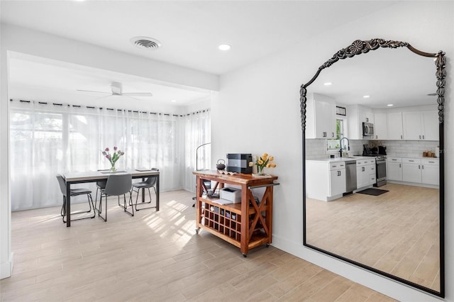 dining space with sink, ceiling fan, and light hardwood / wood-style flooring