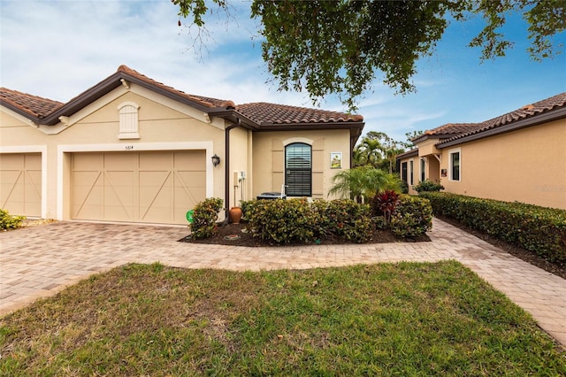 mediterranean / spanish-style home with a garage and a front lawn