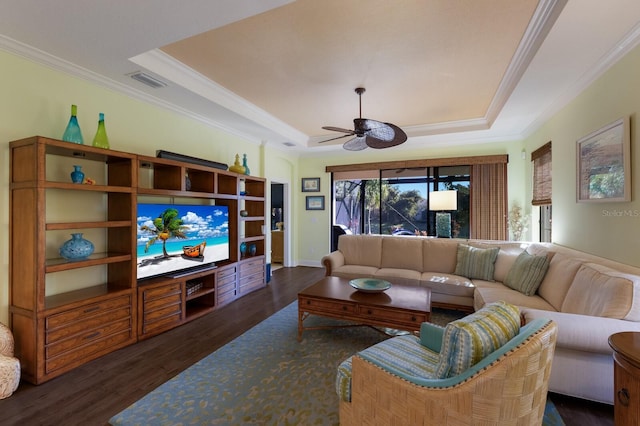 living room with dark wood-style flooring, crown molding, a raised ceiling, visible vents, and ceiling fan