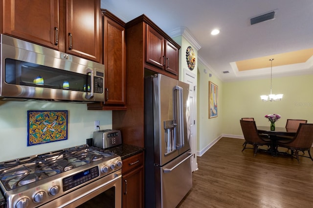 kitchen featuring dark wood-style flooring, crown molding, a raised ceiling, visible vents, and appliances with stainless steel finishes