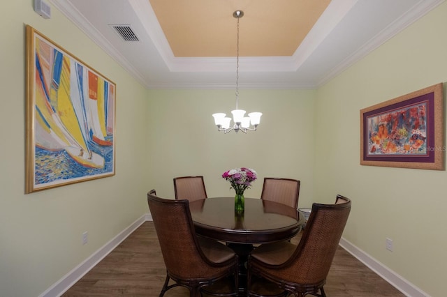 dining area featuring a raised ceiling, visible vents, dark wood-type flooring, a chandelier, and baseboards