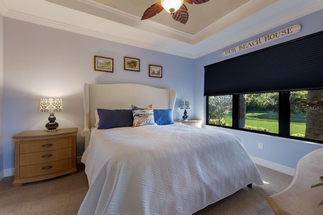 bedroom featuring baseboards, light colored carpet, ceiling fan, ornamental molding, and a tray ceiling