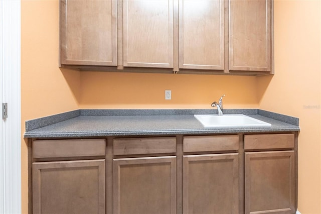 kitchen featuring dark countertops and a sink