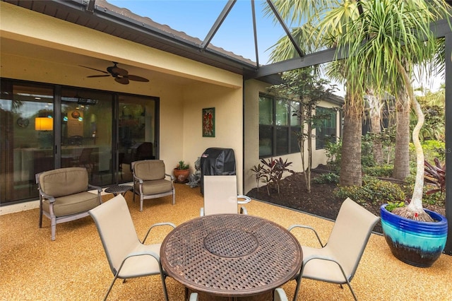 view of patio / terrace with glass enclosure, a grill, and a ceiling fan