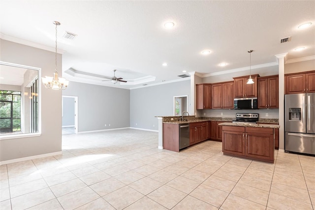 kitchen featuring open floor plan, stainless steel appliances, hanging light fixtures, and a peninsula