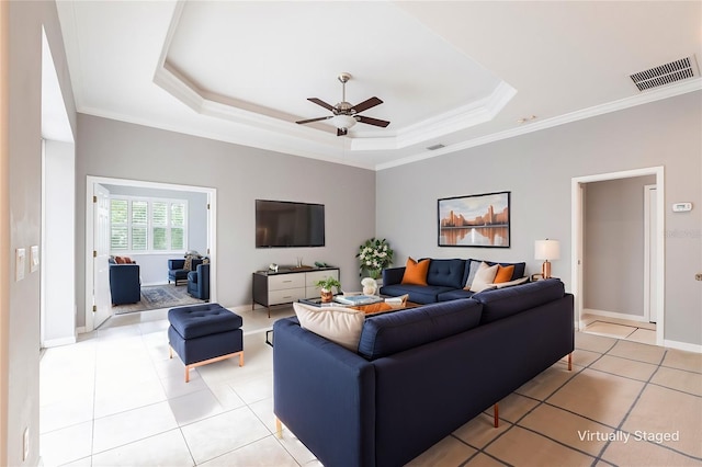 living area featuring visible vents, a tray ceiling, ornamental molding, and light tile patterned flooring