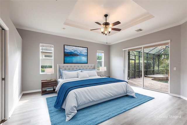 bedroom with visible vents, access to outside, light wood finished floors, a raised ceiling, and crown molding