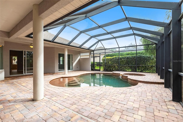 view of swimming pool featuring a pool with connected hot tub, a lanai, a patio, and ceiling fan