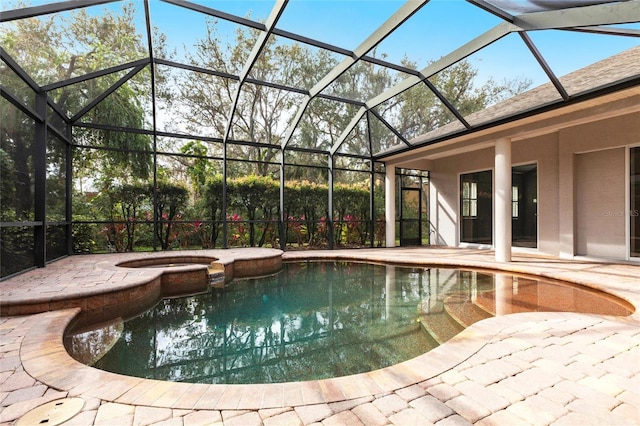 view of swimming pool with a pool with connected hot tub, glass enclosure, and a patio