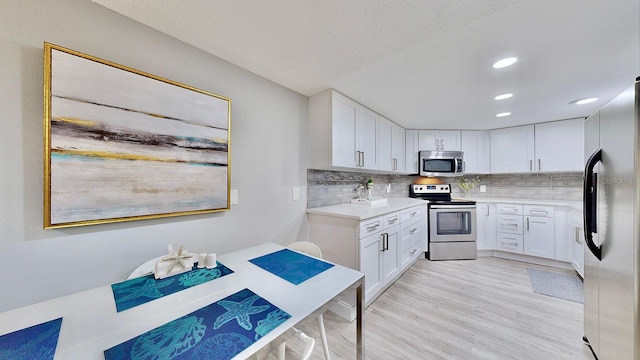 kitchen featuring backsplash, stainless steel appliances, and white cabinets