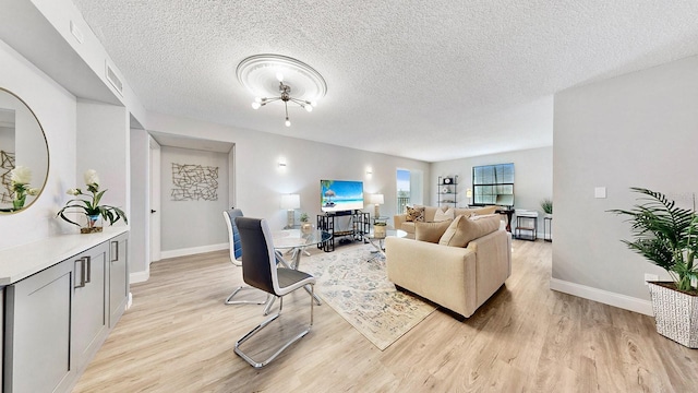 living room featuring a textured ceiling and light wood-type flooring