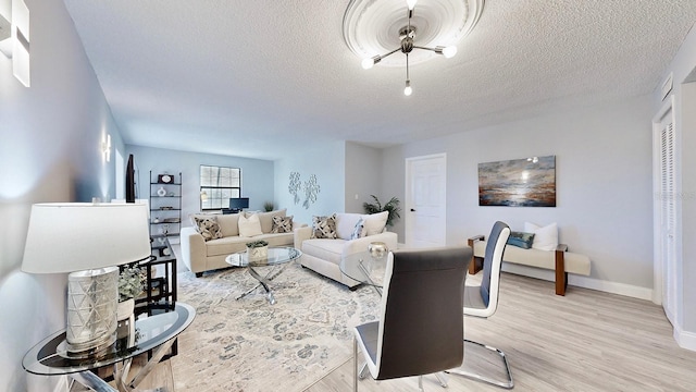 living room with a textured ceiling and light hardwood / wood-style flooring