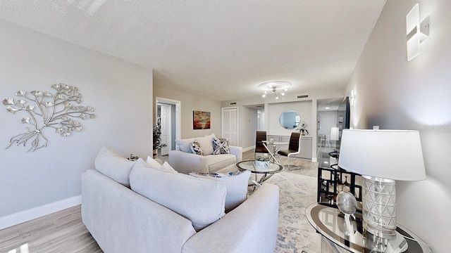 living room with light hardwood / wood-style flooring and a textured ceiling