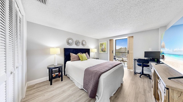 bedroom featuring access to outside, a textured ceiling, and light wood-type flooring