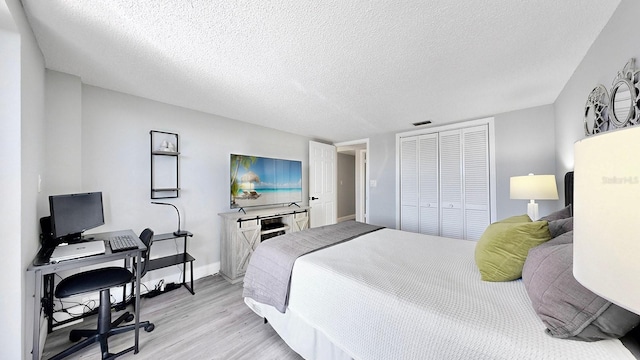 bedroom featuring a textured ceiling, light hardwood / wood-style floors, and a closet