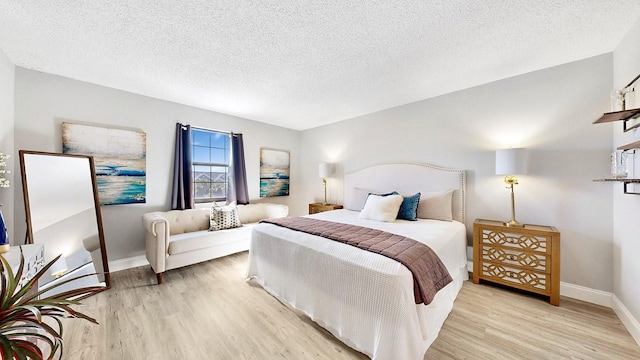 bedroom featuring light hardwood / wood-style floors and a textured ceiling