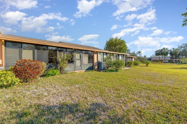 back of house featuring a yard and central air condition unit