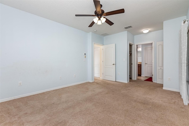 unfurnished bedroom with visible vents, light carpet, baseboards, and a textured ceiling