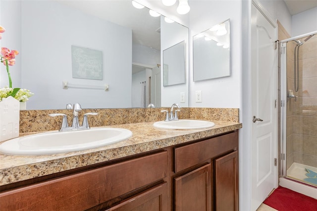 bathroom with a stall shower, a sink, and double vanity