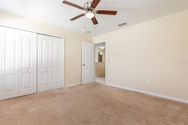 unfurnished bedroom with a closet, visible vents, carpet flooring, ceiling fan, and baseboards