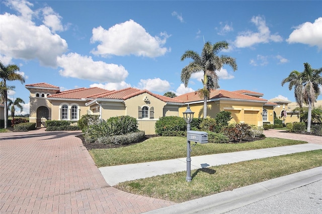 mediterranean / spanish-style home with a garage and a front yard