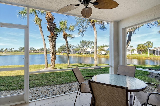 sunroom / solarium with a water view and ceiling fan