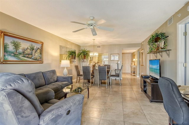 living room featuring light tile patterned floors and ceiling fan with notable chandelier